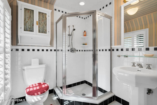 full bathroom with toilet, a stall shower, tile walls, and wallpapered walls