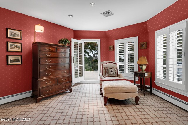 sitting room featuring wallpapered walls, baseboards, visible vents, and light colored carpet