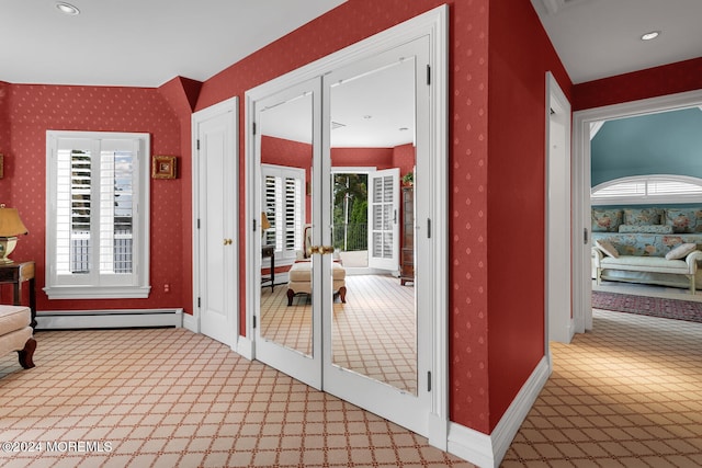 hallway with wallpapered walls, baseboards, a baseboard radiator, french doors, and carpet floors