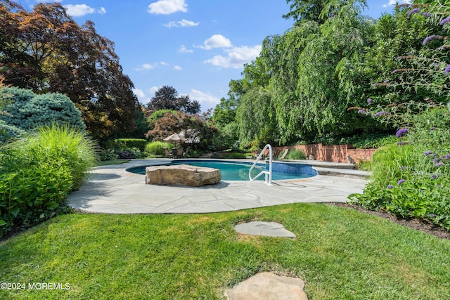 outdoor pool featuring fence, a lawn, and a patio