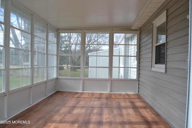 unfurnished sunroom featuring wood walls and wood finished floors