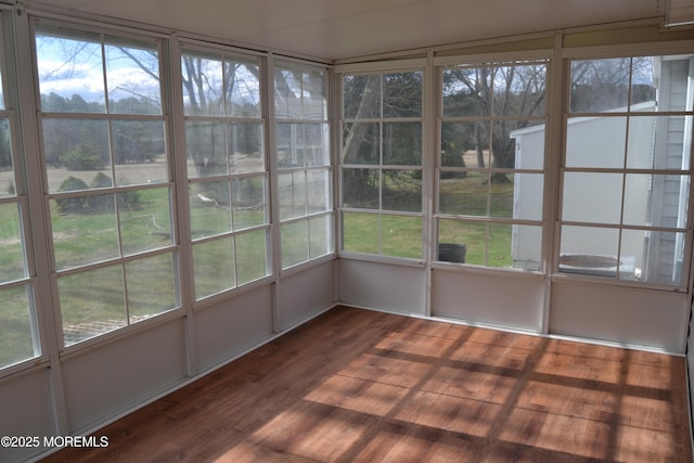 unfurnished sunroom with wood finished floors and a healthy amount of sunlight
