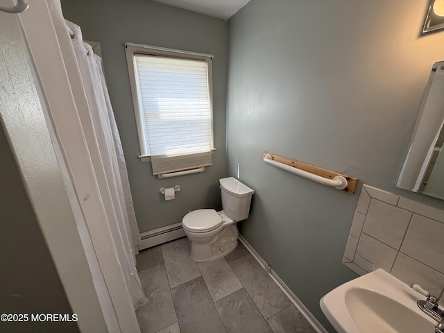 bathroom featuring a baseboard radiator, a sink, marble finish floor, baseboards, and toilet