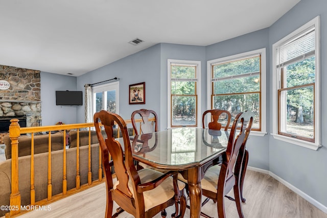 dining space with plenty of natural light, light wood-type flooring, visible vents, and baseboards