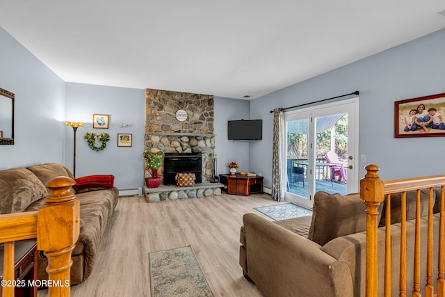 living area with light wood-type flooring, a fireplace, and a baseboard radiator