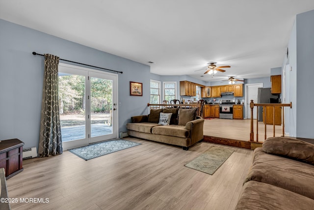 living area featuring light wood finished floors, a baseboard radiator, visible vents, and a ceiling fan