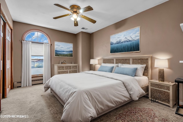 bedroom with a ceiling fan, a baseboard radiator, visible vents, and light carpet