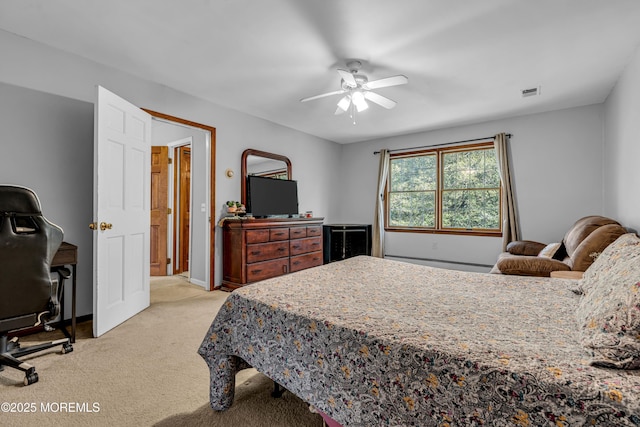 bedroom featuring light colored carpet, visible vents, baseboard heating, ceiling fan, and baseboards