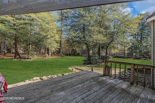 wooden terrace featuring a lawn