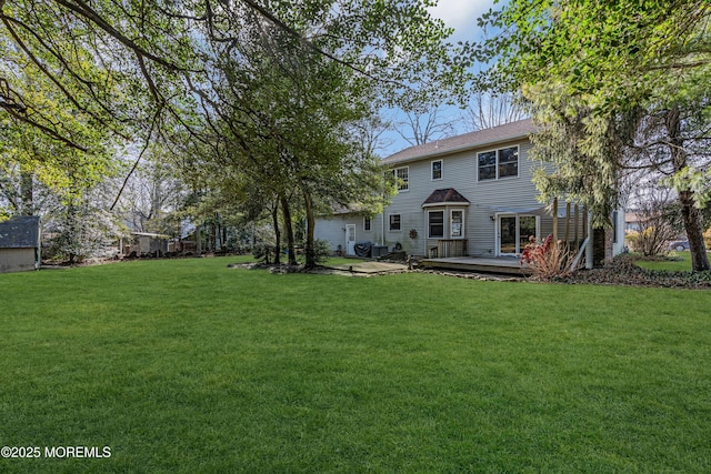 back of property featuring a yard and a wooden deck