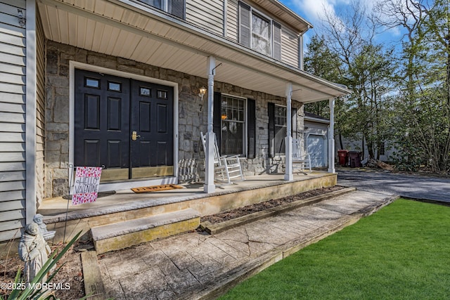 property entrance with stone siding and a porch