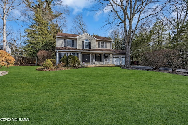 view of front of property with a front lawn, fence, and an attached garage