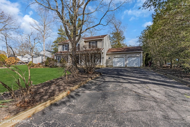 view of front facade featuring a garage, driveway, and a front yard