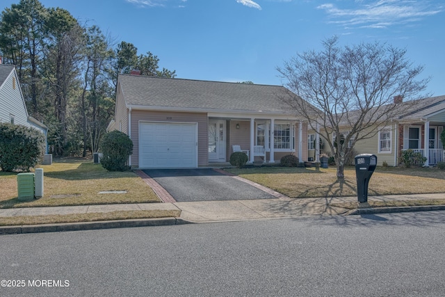 view of front facade with aphalt driveway, a front yard, a shingled roof, and an attached garage