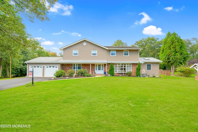 view of front of property with a front yard, brick siding, driveway, and an attached garage