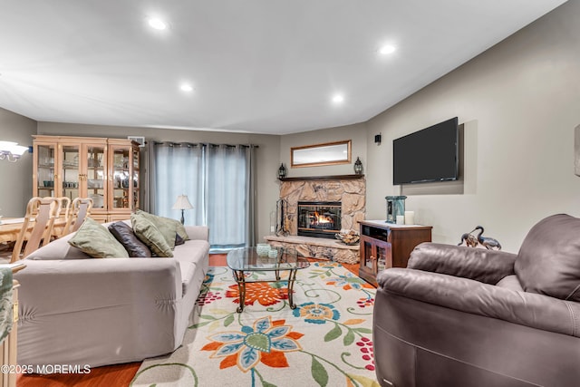 living area with recessed lighting, a fireplace, and wood finished floors