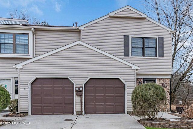 view of property featuring an attached garage and concrete driveway