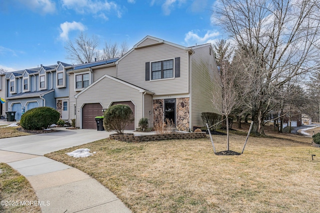 view of front facade with a garage, stone siding, a front lawn, and concrete driveway