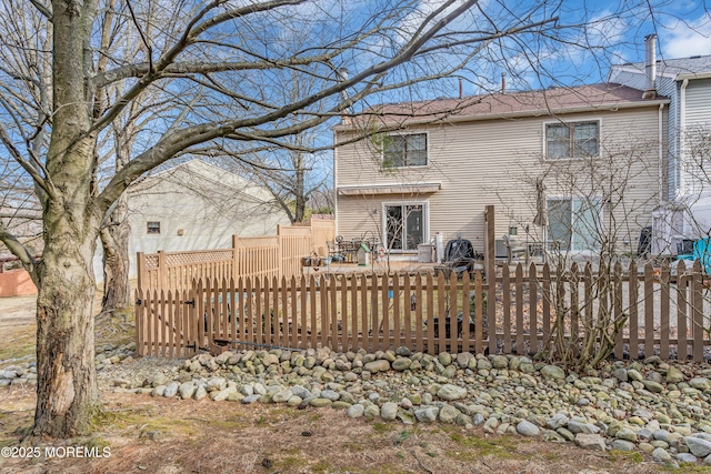 back of house with fence and a wooden deck