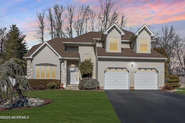 view of front of property with an attached garage, aphalt driveway, a front lawn, and roof with shingles