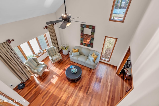 living area with high vaulted ceiling and wood finished floors