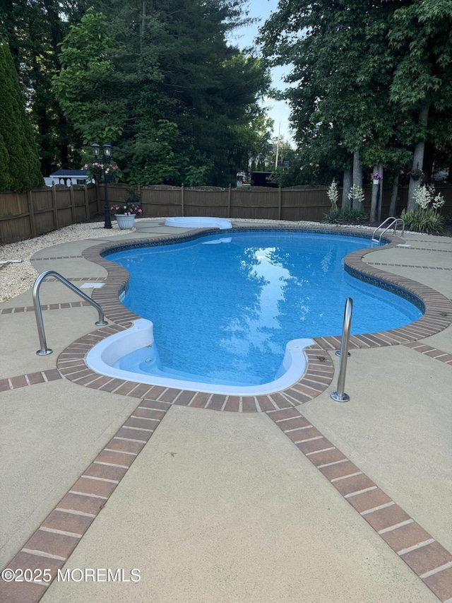 view of pool featuring a patio area, a fenced backyard, and a fenced in pool