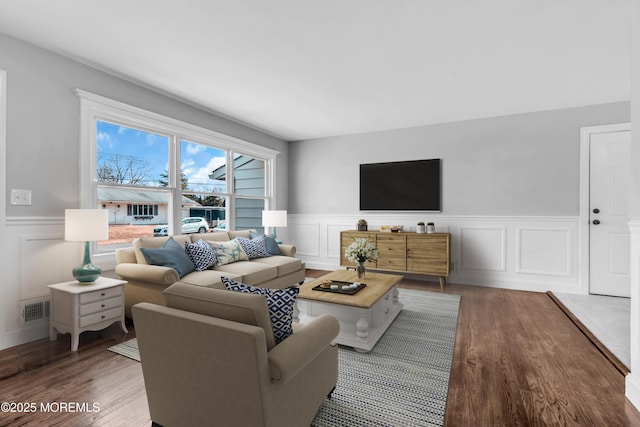 living area featuring dark wood-style floors, wainscoting, and visible vents