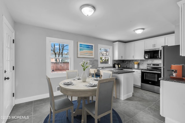 kitchen with tasteful backsplash, white cabinetry, stainless steel appliances, and tile patterned flooring