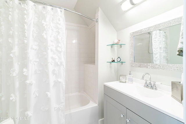 bathroom featuring vaulted ceiling, shower / bath combination with curtain, and vanity