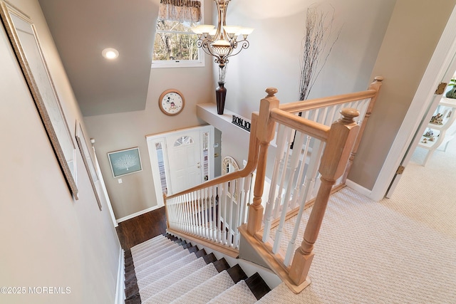 stairs featuring baseboards and a chandelier