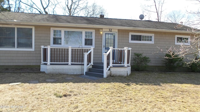 single story home with a shingled roof and a front lawn