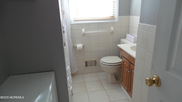 bathroom featuring toilet, tile walls, vanity, visible vents, and tile patterned floors