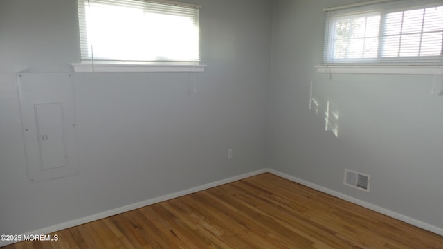 spare room with visible vents, baseboards, and wood finished floors