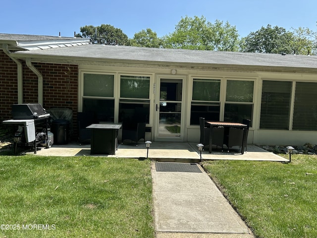 882 Balmoral Ct Unit D, Lakewood, NJ 08701 - view of exterior entry featuring a patio area, brick siding, a lawn, and a shingled roof