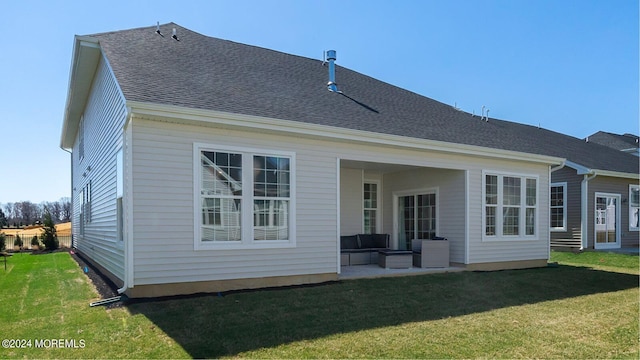 rear view of house with a patio area, a shingled roof, and a lawn