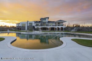 pool at dusk featuring a fenced in pool and a patio area