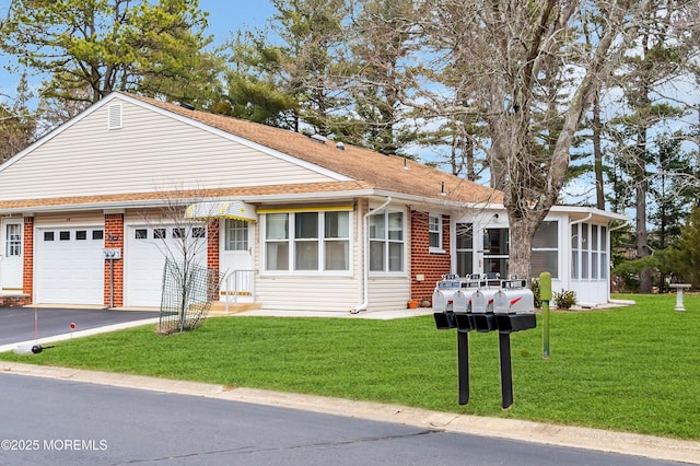 view of front of property with aphalt driveway, a front yard, brick siding, and an attached garage