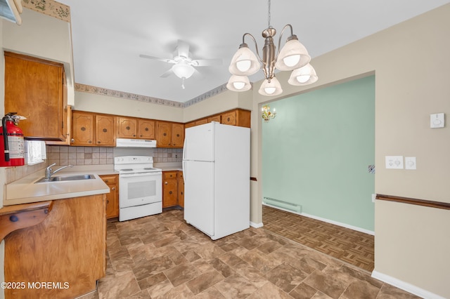 kitchen with under cabinet range hood, white appliances, light countertops, brown cabinets, and decorative light fixtures