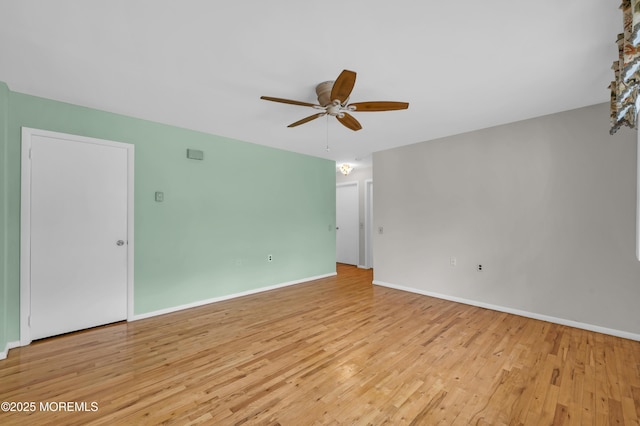 spare room with light wood-style floors, baseboards, and a ceiling fan