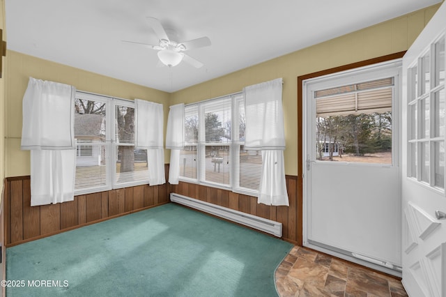 unfurnished sunroom with ceiling fan and a baseboard radiator