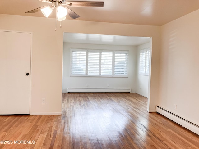 empty room with ceiling fan, baseboard heating, and wood finished floors