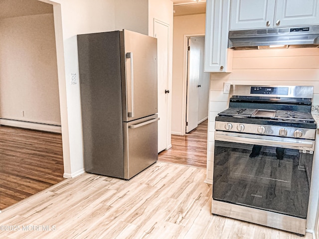 kitchen featuring light wood finished floors, baseboards, appliances with stainless steel finishes, baseboard heating, and under cabinet range hood