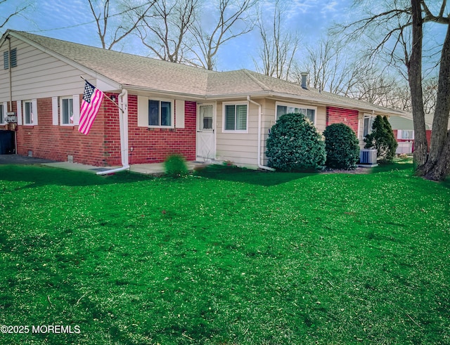 ranch-style house with brick siding, a front lawn, central AC unit, and a shingled roof