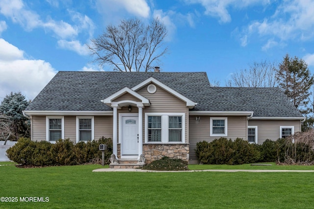 view of front facade with stone siding, a shingled roof, a chimney, and a front yard