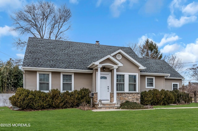 view of front of house featuring stone siding, a shingled roof, a chimney, and a front yard