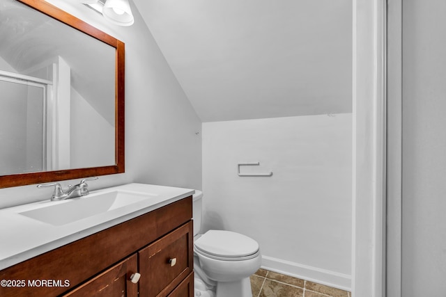 bathroom featuring lofted ceiling, tile patterned flooring, vanity, and toilet