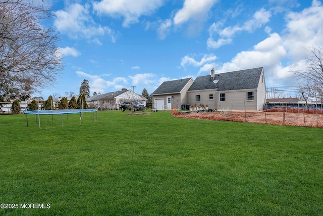 rear view of property with a yard, a trampoline, and a chimney