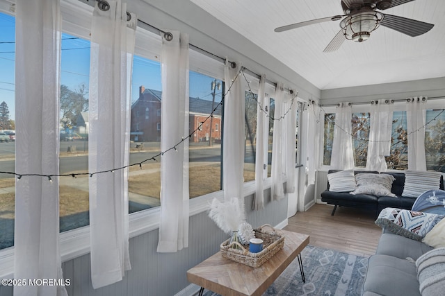 sunroom with lofted ceiling, a wealth of natural light, and a ceiling fan