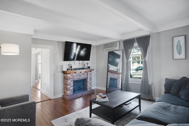 living room with baseboards, dark wood finished floors, a wall unit AC, a fireplace, and beam ceiling