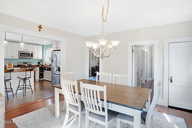 dining space featuring an inviting chandelier, baseboards, and dark wood-style flooring